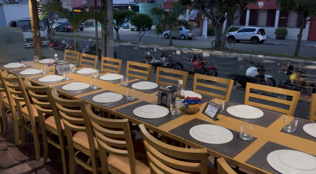 Varanda da Di Pietro com mesa comunitária de frente para a rua